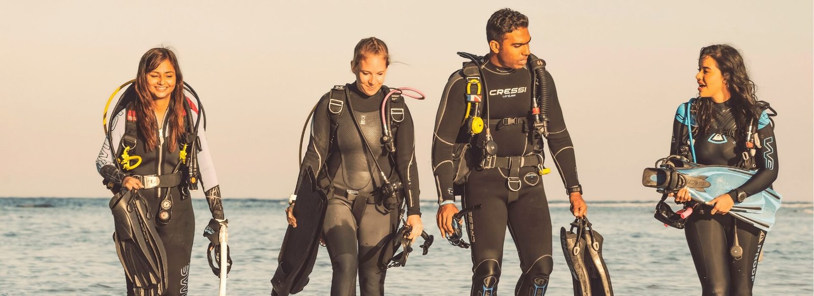 Newly certified PADI MSDT students exiting the ocean after completing specialty dives