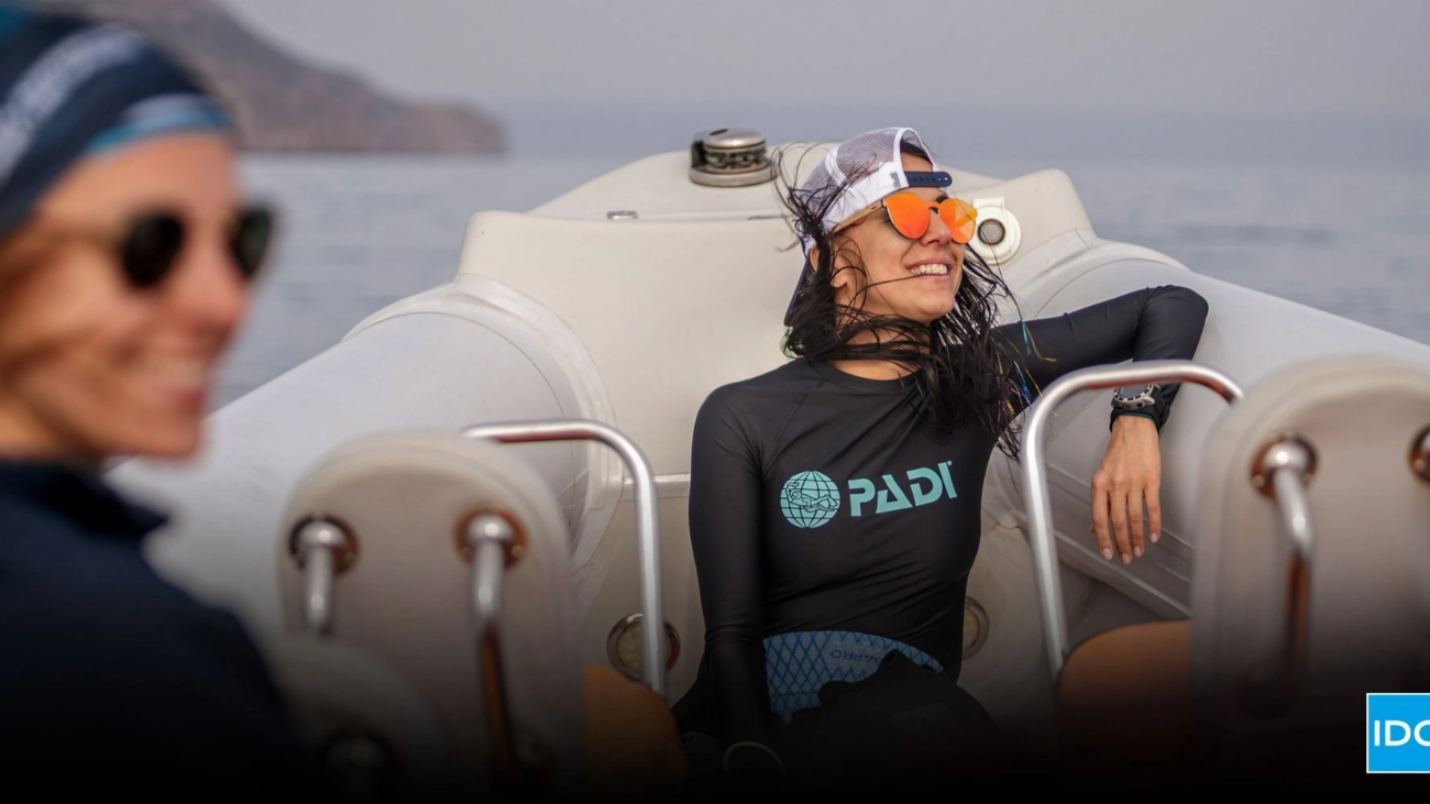 Smiling dive instructor relaxing on a boat after training, representing authentic storytelling in dive marketing and emotional connection with divers.