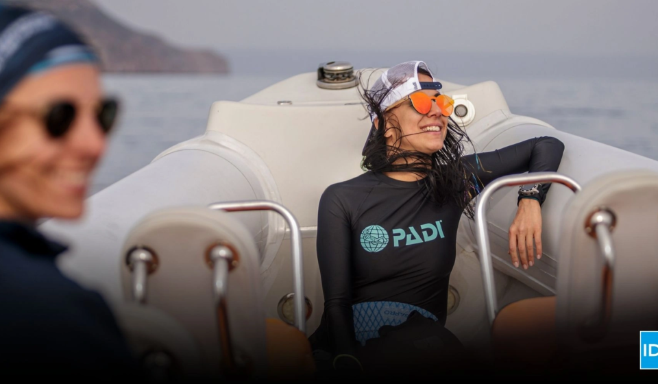 Smiling dive instructor relaxing on a boat after training, representing authentic storytelling in dive marketing and emotional connection with divers.
