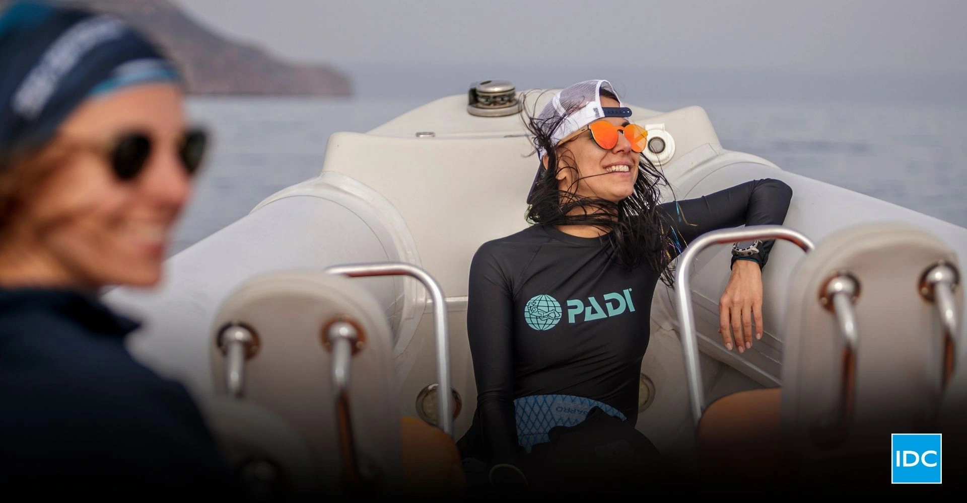 Smiling dive instructor relaxing on a boat after training, representing authentic storytelling in dive marketing and emotional connection with divers.
