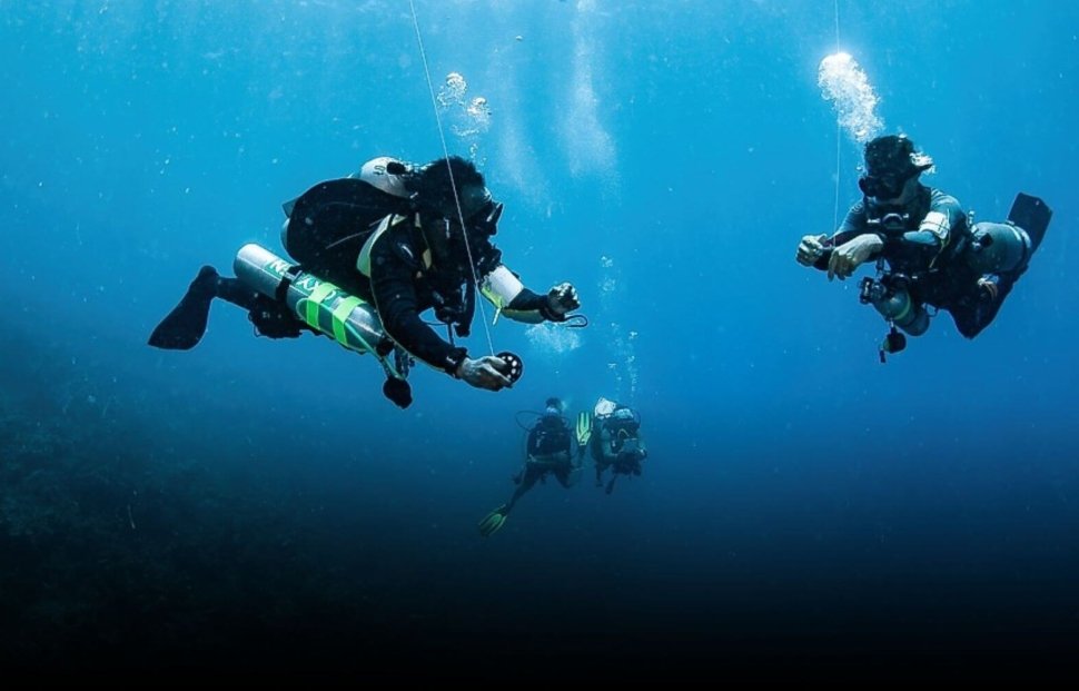Two Tec Divers working together underwater during a decompression stop in Roatán, representing the teamwork and precision of a Tec Safety Diver.