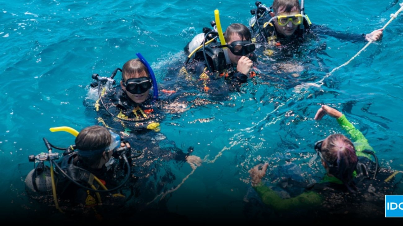 Divemaster course training led by an experienced instructor guiding candidates during a real dive operation