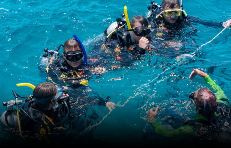 Divemaster course training led by an experienced instructor guiding candidates during a real dive operation